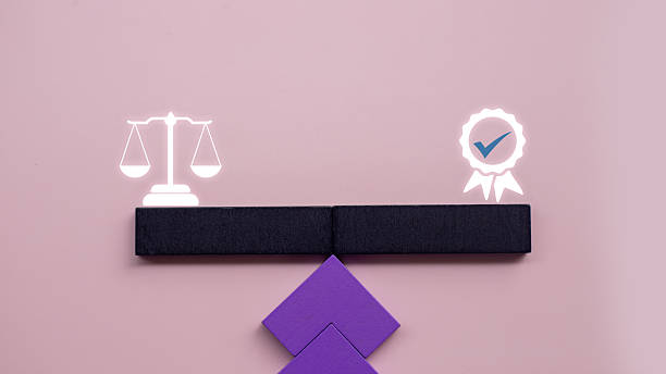 istock Symbolic image showing a balance scale and quality certification ribbon on opposite sides of a wooden block seesaw. Represents ethics, justice, 2230787075