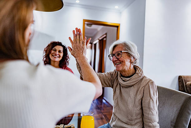 istock Senior woman doing a high-five with her daughter while playing domino at home 2230791525
