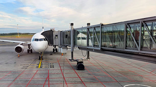 istock Airplane with passenger jet bridge attached. View from the airport window 2230792089
