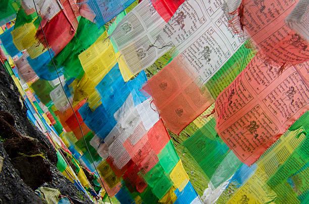 Colorful Tibetan prayer flags fluttering in the wind on a high mountain pass, symbolizing peace, spirituality, and blessings for all.
