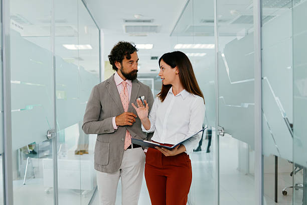 istock Business colleagues discussing work while walking through a brigh, modern office space 2230794544