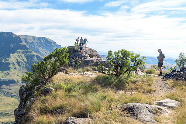 couple men and women with hands up in the mountains of Drakensberg Giant Castle South Africa , during a hiking trip in the mountains at summer