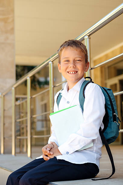 istock back to school, a boy sitting with his textbooks at school and doing his homework, a student going to school in September 2230797612