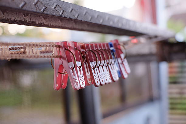 Clothes pegs hanging on empty clothesline with a blurred background in the morning