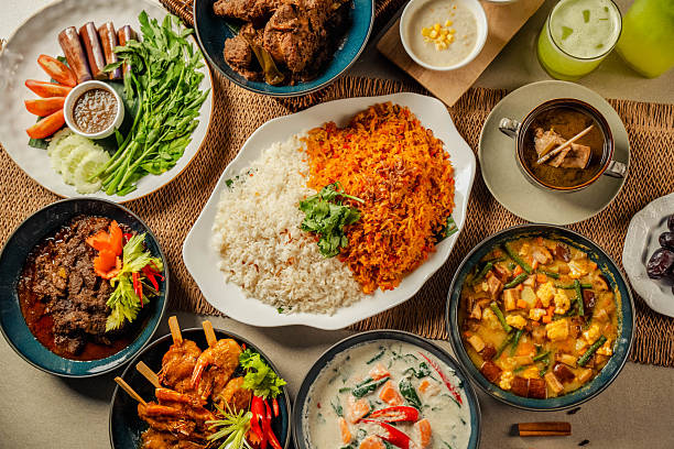 istock Hari Raya Aidilfitri Ramadan Iftar Dinner Gathering with Traditional Asian Malay Halal Cuisine, Family and Friends Enjoying Festive Food Spread at Home with ayam kurma, curry, nasi briyani and ulam 2230802350