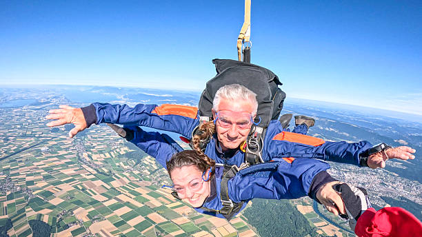 istock Tandem skydivers fly through air together, reach for hand 2230804788
