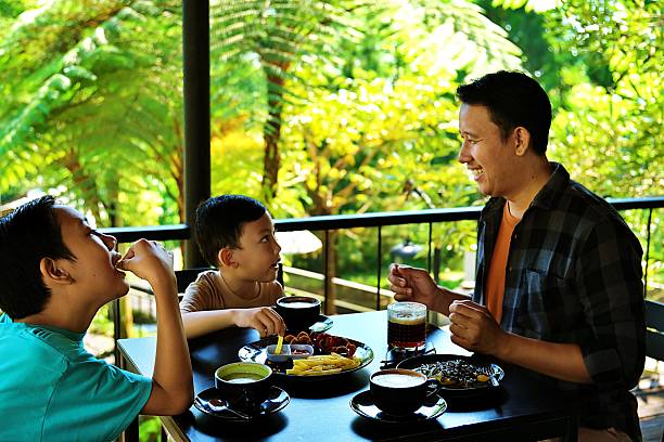 istock Father talking with children while dining outdoors 2230804852