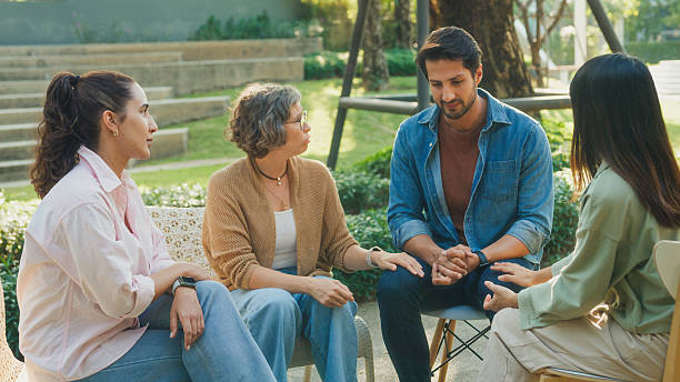 istock Diverse group people engaging in supportive group therapy session, sharing personal stories and advice to promote mental health and recovery in park. Mental health community concept. 2230808326