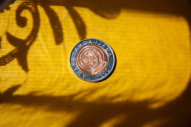 Heaps of money or pile of gold colored golden currency coins arranged as mountain or set or stacks of abundant money placed on a wooden surface over beige gray colored horizontal background with copy space