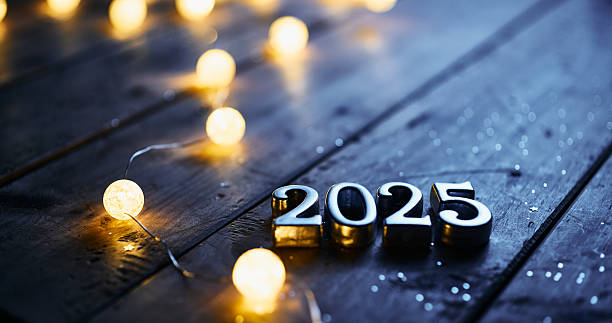 istock Metallic 2025 Numbers with Soft Glowing Lights on Dark Wooden Surface 2230808436