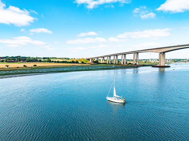 Scenic view of a sailboat cruising on the river orwell, with the orwell bridge in the background, located in ipswich, england
