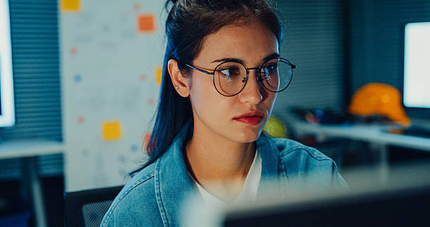 istock Young female engineer working late on a robotic arm prototype in tech lab at night. Machine learning, computer-aided manufacturing, innovation and creativity. AI and Robotics Development. 2230811727