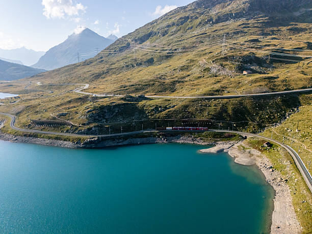 istock Mountain Train Traveling Along Lakeside Track 2230814658