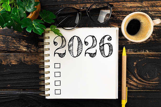 istock New year resolutions 2026 on desk. 2026 resolutions list with notebook, coffee cup on wooden table. Goals, resolutions, plan, action, checklist concept. New Year 2026 template 2230814841