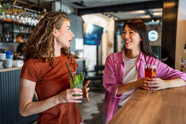 istock Two young women enjoying drinks and conversation at a bar 2230818138