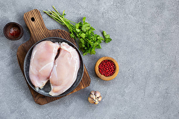 istock Raw chicken breast meat and spices for its preparation on a grey background, top view copy space for text 2230822923