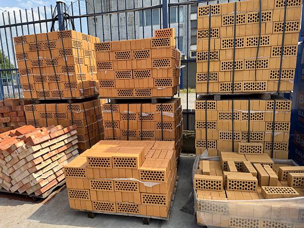 istock Pallets of yellow perforated bricks and red bricks ready for construction 2230823002