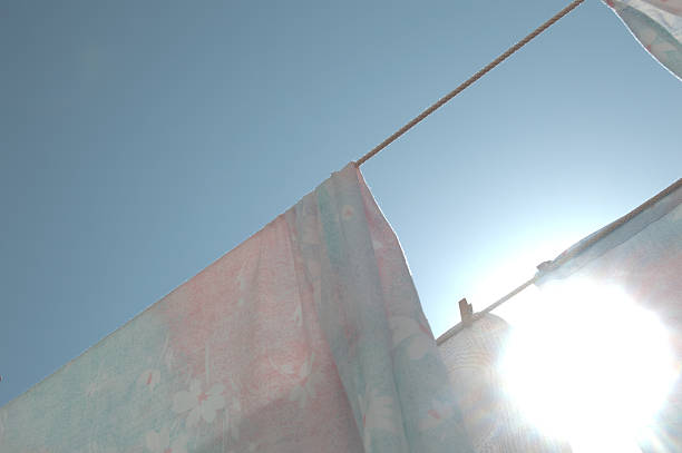 Laundry Day Under the Sun, Clothes drying on a clothesline in the sun, closeup of photo