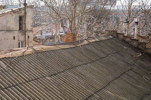 Old house with corrugated slate roof, view from above. The roof needs repair