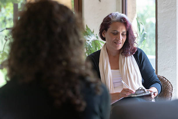 istock Hispanic woman speaking to patient in therapy or coaching session 2230827475