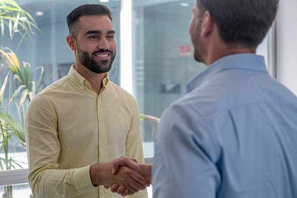 istock Two businessmen shaking hands in modern office 2230829479