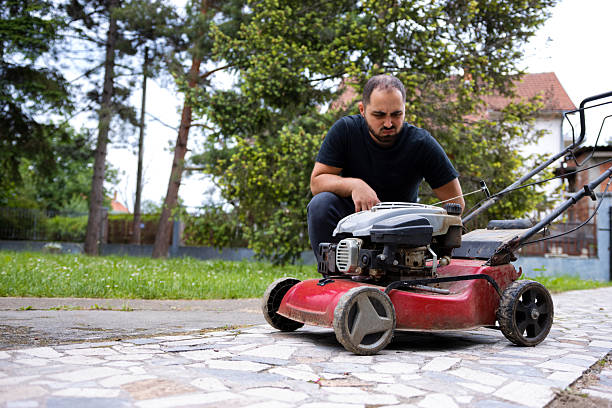 istock Angry man next to a red lawnmower. Old lawnmower. Broken lawnmower 2230832412