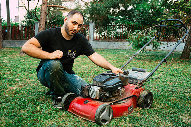 istock Angry man next to a red lawnmower. Old lawnmower. Broken lawnmower 2230832415