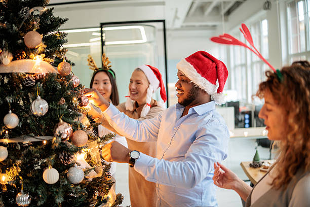 istock Colleagues Decorating Festive Christmas Tree at Workplace 2230834913
