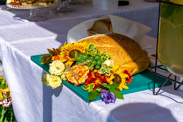 istock Traditional harvest bread decorated with flowers and grapes on a table with white tablecloth, harvest festival, Polish folk tradition, rural celebration, local culture, countryside event. 2230836256