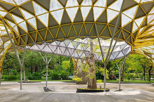 istock Perdana Botanical Garden, Kuala Lumpur, Malaysia with geometric yellow structure with a tree in the center, creating a blend of nature and modern architecture in an open park space in Asia 2230839920