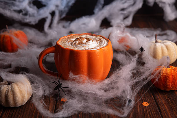 istock Halloween pumpkin latte with whipped cream and spooky decor on a wooden background. 2230840321