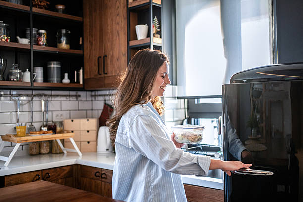 istock Woman putting leftovers in refrigerator in modern kitchen 2230843849