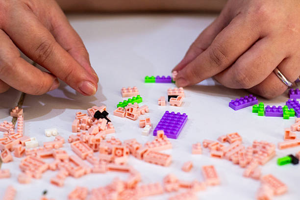 istock Hands creatively construct with toy building blocks, fostering focus and imaginative play on white 2230847162