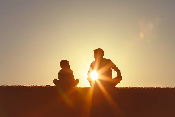 istock Father and son bonding, talking, enjoying each other company at sunset. 2230855071