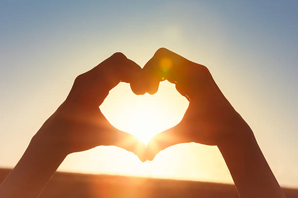 istock Woman making heart shape against a sunset. 2230855111