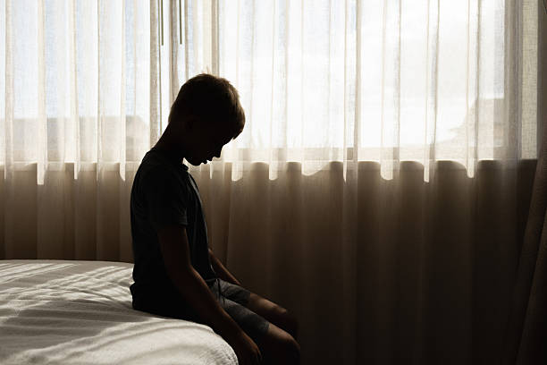 istock Sad lonely unhappy child boy silhouette crying sitting at home 2230857155
