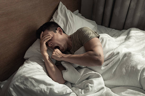 istock Man suffering from insomnia lying in bed yawning getting bad sleep, insomnia, over worked ,tired, unmotivated. 2230857424