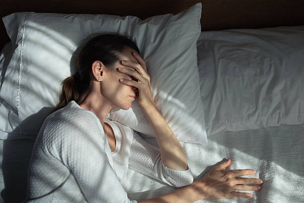 Woman lying in bed feeling tired and stressed can't sleep.