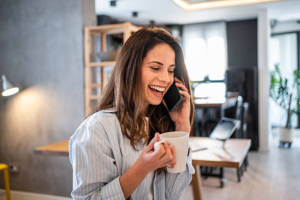 istock Young woman working from home, talking on phone and drinking coffee 2230861442