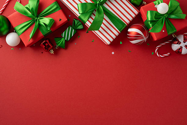 istock Brightly wrapped holiday presents and decorative ornaments against a vibrant red surface, enhancing the holiday spirit 2230861568