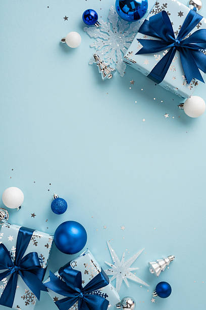 istock Christmas vertical decorations in a festive blue theme featuring ornaments, gifts, and snowflakes on a light blue background 2230861574