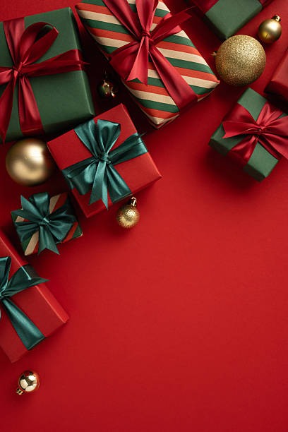 istock Colorful vertical gift boxes decorated with ribbons surrounded by ornaments on a vibrant background conveying a festive Christmas mood 2230861582