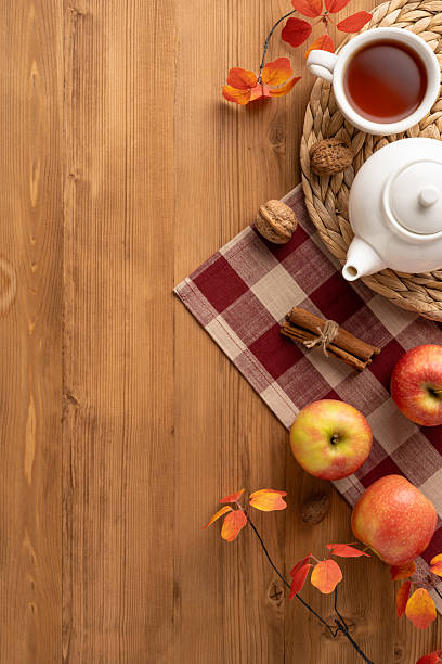 istock Warm and inviting vertical autumn tea scene featuring a tea set, apples, nuts, and fall decor 2230861598