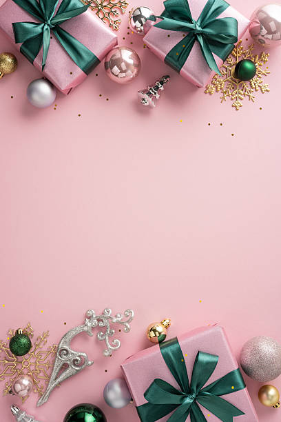 istock Festive vertical composition with pink-wrapped gifts and decorative ornaments on a delicate pink backdrop 2230861600
