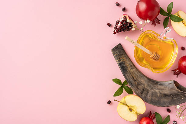 istock Rosh Hashanah themed setup featuring honey, apples, pomegranates, and shofar on a pastel background to represent the Jewish New Year celebration and its traditional symbols of sweetness and renewal 2230861647