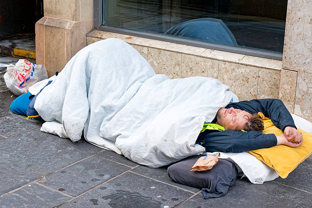 beggar man lying on the floor homeless depression help money problems. High quality photo