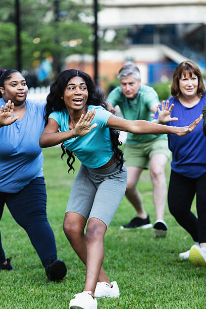 istock Young woman leading tai chi class in park 2230863954