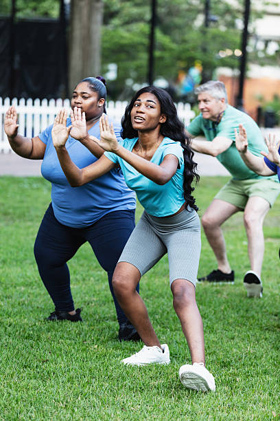 istock Young woman leading tai chi class in park 2230863957
