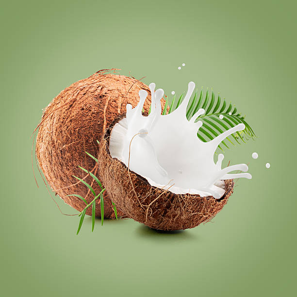 istock coconuts with palm leaf and milk splash on a light green  background 2230864502