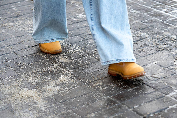 istock Anti-icing chemicals. Man walking on the street treated with technical salt or de-icing chemicals 2230866855
